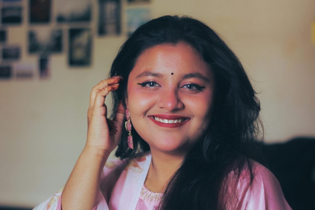 Portrait of a cheerful woman in pink traditional South Asian attire, indoors.